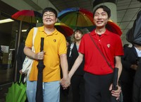 Gay couple So Seong-wook, left, and Kim Yong Min, leave the Supreme Court building in Seoul, South Korea, on July 18, 2024. (Suh Dae-yeon/Yonhap via AP)