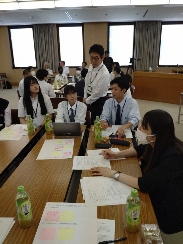 学区制のあり方などについて意見を出し合う高校生の背後で耳を傾ける中川斉史・徳島県教育長＝徳島市万代町1の県庁講堂で2024年7月25日午後3時26分、植松晃一撮影