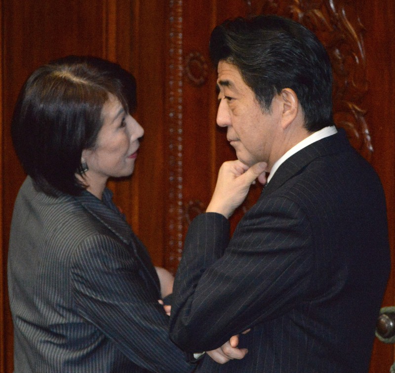 衆院本会議場の議席後方で高市早苗自民党政調会長（左）の言葉を聞く安倍晋三首相＝国会内で2013年11月19日午後1時44分、藤井太郎撮影