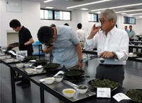 Participants in this season's last Uji tea leaves auction check the quality of crops at the Uji tea distribution center of the Japan Agricultural Cooperatives (JA) Group's Zen-Noh Kyoto in Joyo, Kyoto Prefecture, on July 31. (Mainichi/Kentaro Suzuki)