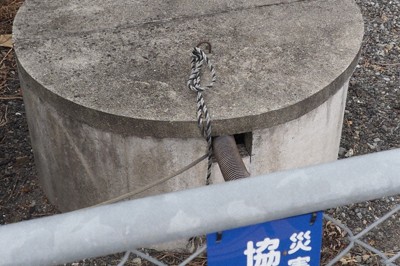 「災害時協力井戸」の存在を知らせるプレートと登録されている井戸＝徳島県阿波市阿波町平川原南で、植松晃一撮影