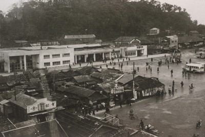 1945年7月の徳島大空襲で焼失し、木造の仮設駅舎を経て51年に完成した徳島駅。駅前にはバラック建ての店などが並ぶ。52年ごろの撮影で、この年、闇市は完全に撤去された（徳島県立文書館提供）