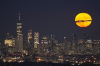 The moon rises through clouds over the skyline of lower Manhattan in this view from West Orange, N.J., on Aug. 1, 2023, during a supermoon period. (AP Photo/Seth Wenig, File)