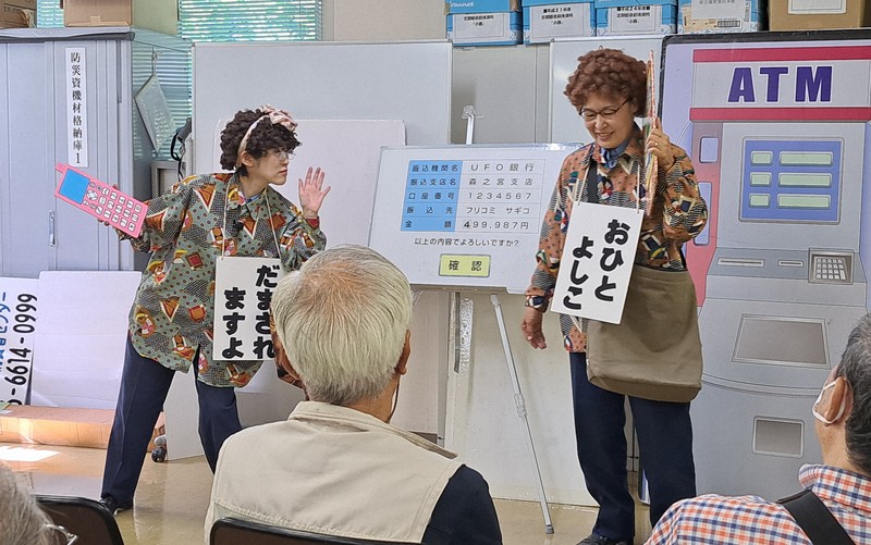 還付金詐欺の手口を寸劇で紹介する警察官＝大阪府豊中市で2024年7月27日、田中謙吉撮影