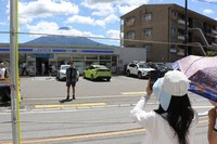 A tourist holds up her smartphone to take a photo at the site where a screen has been removed to block photography, in Fujikawaguchiko, Yamanashi Prefecture, on Aug. 20, 2024. (Mainichi/Tatsuki Noda)