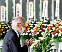A man places his hands together in front of a flower stand during an event to mourn the victims of internment camps in Siberia and Mongolia after World War II, at Chidorigafuchi National Cemetery in Tokyo's Chiyoda Ward on Aug. 23, 2020. (Mainichi/Natsuki Nishi)