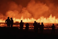 Tourists and visitors try to get a view of the eruption from a distance from the intersection between Reykjanesbraut, Iceland, and the road to Grindavik, on Aug. 22, 2024. (AP Photo/Marco di Marco)