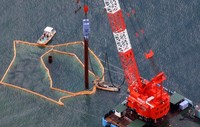 A crane barge is seen sinking a steel pipe into Oura Bay, where soft ground was found on the seafloor, as part of work to relocate U.S. Marine Corps Air Station Futenma from Ginowan to the Henoko district of Nago, both in Okinawa Prefecture, in this photo taken in Nago from a Mainichi Shimbun airplane on Aug. 20, 2024. (Mainichi/Yuki Miyatake) 