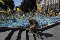 A veteran pays his respect at a makeshift memorial for fallen Ukrainian soldiers during Ukrainian Independence Day on Independence Square in Kyiv, Ukraine, Aug. 24, 2024. (AP Photo/Efrem Lukatsky)