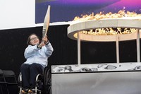 British Paralympian Helene Raynsford holds the Paralympic Torch during the flame lighting ceremony in Stoke Mandeville, England, widely considered the birthplace of the Paralympic Games, on Aug. 24, 2024. (AP Photo/Thomas Krych)