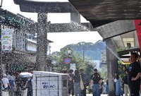 The ground on the approach to Dazaifu Tenmangu shrine is cooled with water in Dazaifu, Fukuoka Prefecture, on Sept. 2, 2024. (Mainichi/Minoru Kanazawa)
