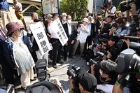 A sign reading "partial victory" is held up in front of the Nagasaki District Court on Sept. 9, 2024. Chiyoko Iwanaga, the plaintiff group's leader, is seen at the front left. (Mainichi/Minoru Kanazawa)