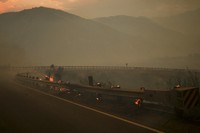 Wood posts along a railing on the side of a road smolders after the Line Fire swept through, on Sept. 7, 2024, near Running Springs, Calif. (AP Photo/Eric Thayer)