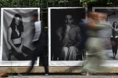 公園のフェンスに並んで掲げられた障害者たちの写真。多くの人たちが前を通り過ぎていく＝パリで2024年9月7日、春増翔太撮影