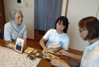 Aya Takesada, right, recalls memories with family while looking at photos left behind by her father, in Kobe's Higashinada Ward on July 24, 2024. (Mainichi/Shinya Yamamoto)