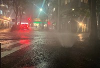 Water spews from a manhole on a drenched street in Tokyo's Shibuya Ward during a torrential downpour on Aug. 21, 2024. (Mainichi/Kanami Ikawa)