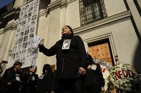 Gaby Rivera, president of the Relatives of Detainees and Missing Persons organization, dances the "Cueca Sola," a tradition dance that has become representative of mourning for those searching for disappeared family members, outside La Moneda presidential palace on the anniversary of the 1973 military coup in Santiago, Chile, on Sept. 11, 2024. (AP Photo/Esteban Felix)