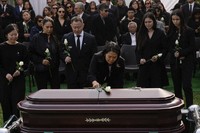 Keiko Fujimori places a flower over the coffin of her father, former President Alberto Fujimori, in Lima, Peru, on Sept. 14, 2024. (AP Photo/Guadalupe Pardo)
