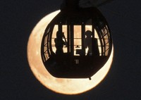 The harvest moon rises in the evening sky behind a Ferris wheel cabin at the Yokohama Cosmo World amusement park in the city's Nishi Ward on Sept. 17, 2024. (Mainichi/Koichiro Tezuka)