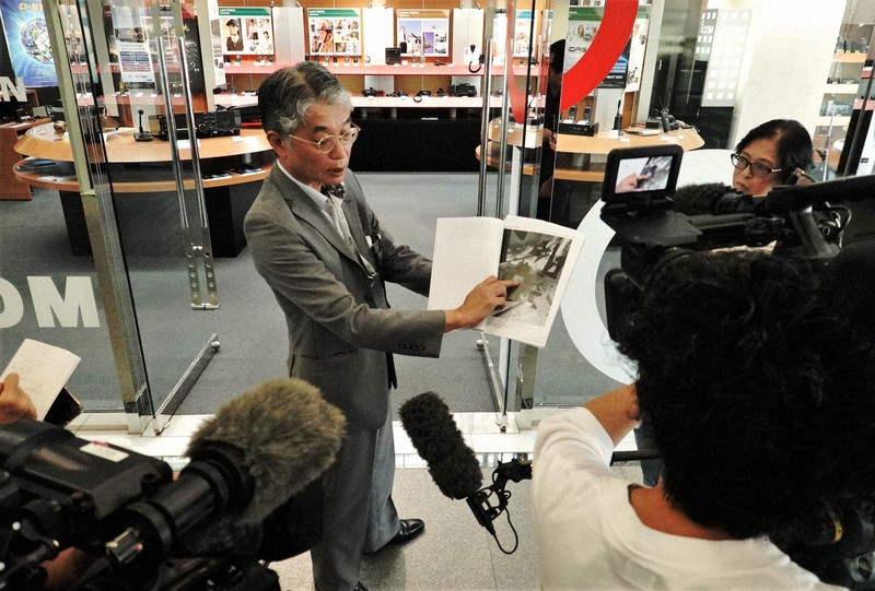 爆発した無線機の写真を手に、報道陣の質問に応じる無線通信機器メーカー「アイコム」の榎本芳記取締役（中央）＝大阪市平野区で2024年9月19日午前11時40分、岩本一希撮影
