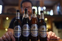 Head Brewmaster Tobias Zollo poses behind non-alcoholic beer at the Weihenstephan brewery in Freising, Germany, on Sept. 20, 2024. (AP Photo/Matthias Schrader)