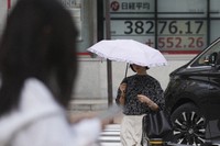 A person walks near an electronic stock board showing Japan's Nikkei index at a securities firm on Sept. 24, 2024, in Tokyo. (AP Photo/Eugene Hoshiko)