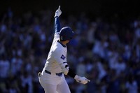 Los Angeles Dodgers' Shohei Ohtani celebrates toward his dugout as he heads to first for a solo home run during the ninth inning of a baseball game against the Colorado Rockies, on Sept. 22, 2024, in Los Angeles. (AP Photo/Mark J. Terrill)