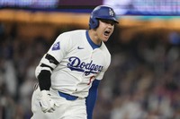Los Angeles Dodgers designated hitter Shohei Ohtani reacts as he singles during the sixth inning of a baseball game against the San Diego Padres in Los Angeles, on Sept. 25, 2024. Will Smith scored. (AP Photo/Ashley Landis)