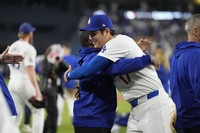 Los Angeles Dodgers designated hitter Shohei Ohtani celebrates with members of the team after his team defeated the San Diego Padres 7-2 in a baseball game to clinch the National League West division title, on Sept. 26, 2024, in Los Angeles. (AP Photo/Ashley Landis)