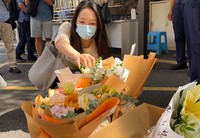 A Chinese woman offers flowers in front of Shenzhen Japanese School's gate in Shenzhen, Guangdong province, on Sept. 19, 2024. (Mainichi/Hideto Okazaki)