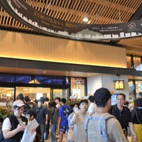 たくさんの人が行き交うJR松山駅新駅舎のコンコース。奥の新商業エリア「だんだん通り」も盛況だった＝松山市の同駅で2024年9月29日、山中宏之撮影