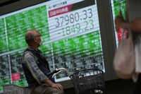 A man looks at monitors showing Japan's Nikkei 225 index at a securities firm in Tokyo, on Sept. 30, 2024. (AP Photo/Hiro Komae)