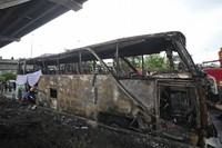 A rescuer inspects a bus that caught fire carrying young students with their teachers in suburban Bangkok, on Oct. 1, 2024. (AP Photo/Sakchai Lalit) 