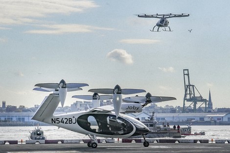 An electric vertical takeoff and landing (eVTOL) aircraft, flies above the Joby eVTOL aircraft, during a demonstration of eVTOLs on Nov. 13, 2023, in New York. (AP Photo/Bebeto Matthews, File)