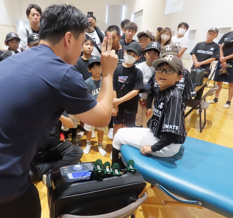 野球スクールの説明会で、スタッフから施設に備えられた機器などの話を聞く小学生ら＝岩手県花巻市で2024年9月7日午前10時43分、早川健人撮影