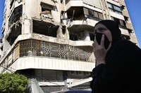A woman reacts in front of an apartment in a multistory building hit by an Israeli airstrike, in central Beirut, Lebanon, on Oct. 3, 2024. (AP Photo/Hussein Malla)