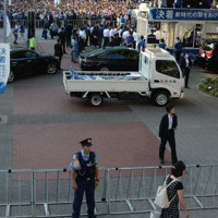 小泉進次郎元環境相が演説したステージ（右上）。大勢の警察官が厳重な警戒に当たり、周囲を鉄柵で取り囲んで聴衆が近づけないようにした＝横浜市中区のJR桜木町駅前で2024年9月8日、柿崎誠撮影