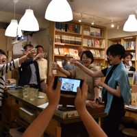 韓江さんのノーベル文学賞受賞決定を祝ってワインで乾杯をする出版関係者ら=東京都千代田区神田神保町1の韓国文学ブックカフェ「チェッコリ」で2024年10月10日午後9時7分、木原真希撮影