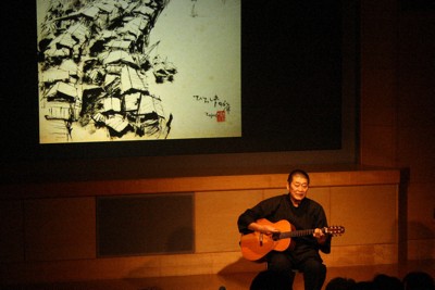 四國五郎の絵を背に熱演する趙博さん＝広島市中区で2024年9月20日午後6時52分、宇城昇撮影