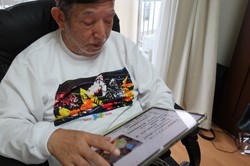 認知症になってから覚えたタブレット端末を使う佐藤雅彦さん＝筆者撮影