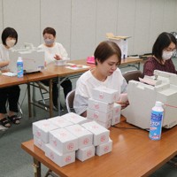 計数機を使って投票用紙の枚数を確認する小倉北区選管職員ら