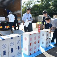 トラックから投票用紙が入った箱を積み下ろす職員ら