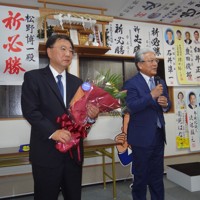 千葉県市原市の小出譲治市長から花束を受け取った松野博一氏（左）＝市原市で28日午前0時20分、浅見茂晴撮影
