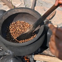 古くに使われていたというルワンダの伝統的なコーヒーの焙煎（ばいせん）方法。鍋に生豆を入れて均等に火が通るようへらでかき混ぜ続ける＝ルワンダ・フイエで2024年7月26日、北山夏帆撮影
