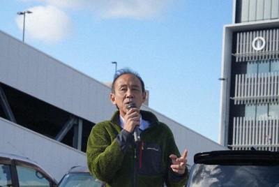 愛車の軽自動車（左奥）に乗り、一人でゲリラ演説を行う辻英之氏＝福井県敦賀市役所で（画像の一部を加工しています）＝高橋隆輔撮影