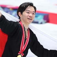 表彰式後に日の丸を背にする鍵山優真＝国立代々木競技場で2024年11月9日、猪飼健史撮影