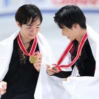 表彰式後の記念撮影でメダルを確認する鍵山優真（左）と壷井達也＝国立代々木競技場で2024年11月9日、猪飼健史撮影