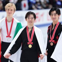表彰式後に記念撮影する（左から）2位でイタリアのダニエル・グラスル、1位の鍵山優真、3位の壷井達也＝国立代々木競技場で2024年11月9日、猪飼健史撮影