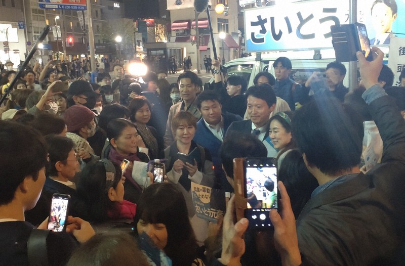 聴衆に取り囲まれ、記念写真に納まる斎藤元彦氏（中央右）＝神戸市中央区で2024年11月11日午後7時33分、栗田亨撮影