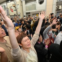 テレビで当選確実のニュースが流れ、喜ぶ斎藤元彦氏の支持者ら＝神戸市中央区で2024年11月17日午後8時1分、北村隆夫撮影